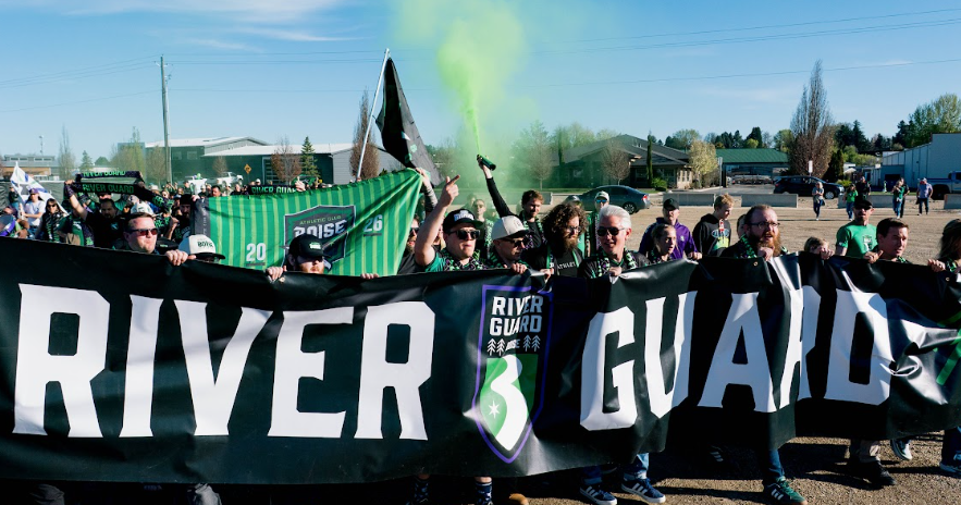 River Guard supporters marching with a matchday banner